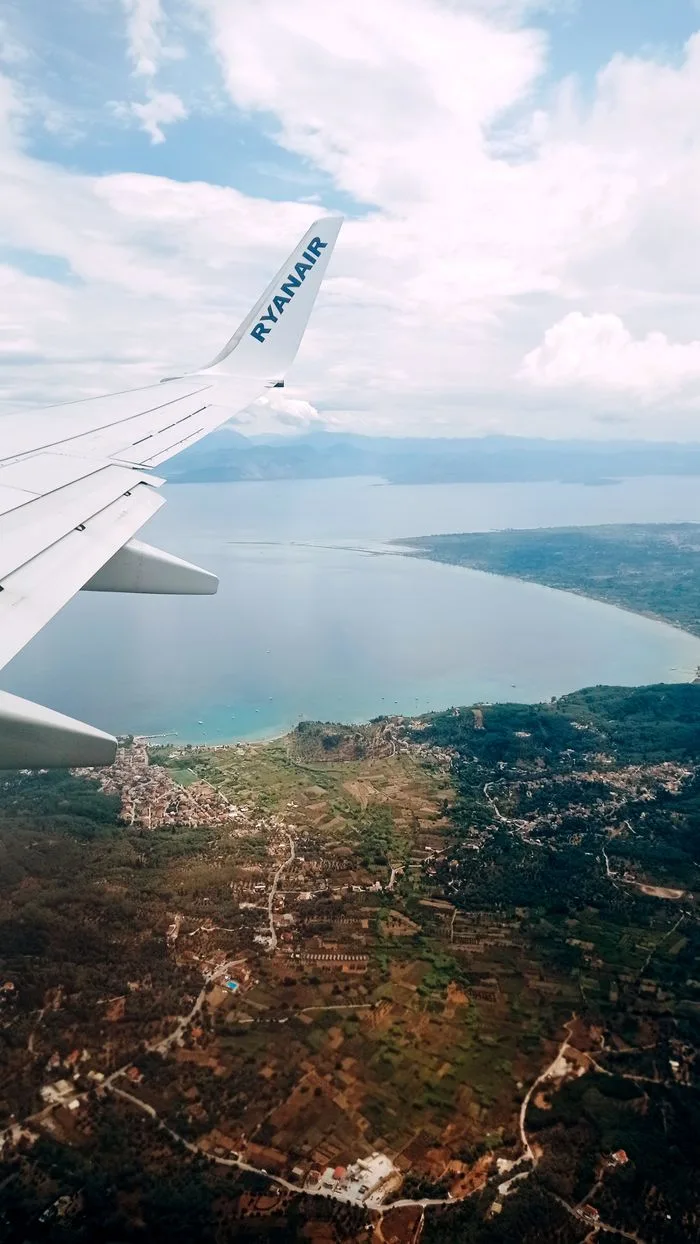 Stunning aerial perspective of Corfu, Greece, with airplane wing and coastline.